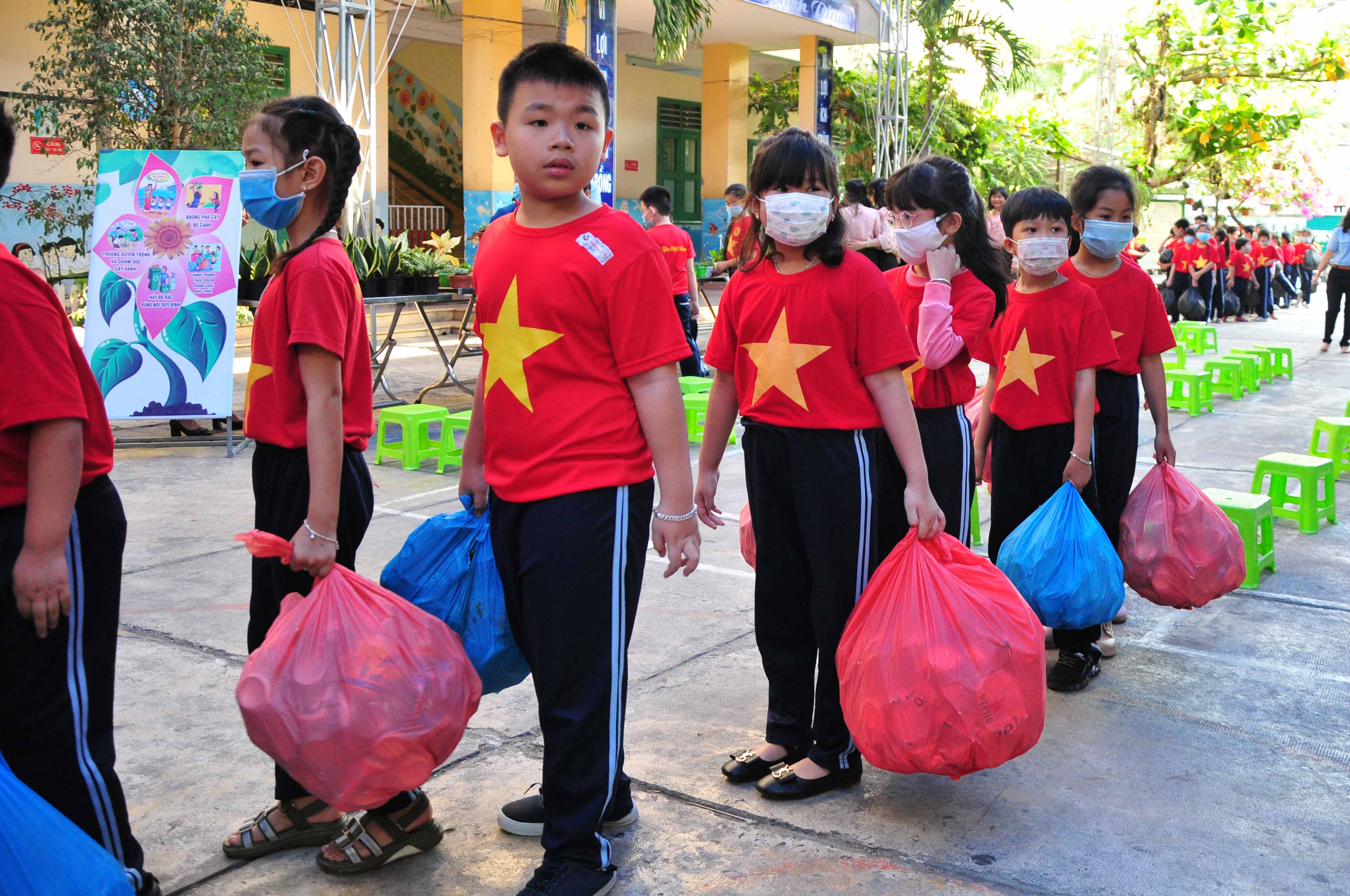 Pupils waiting to exchange trash and old publications for plants