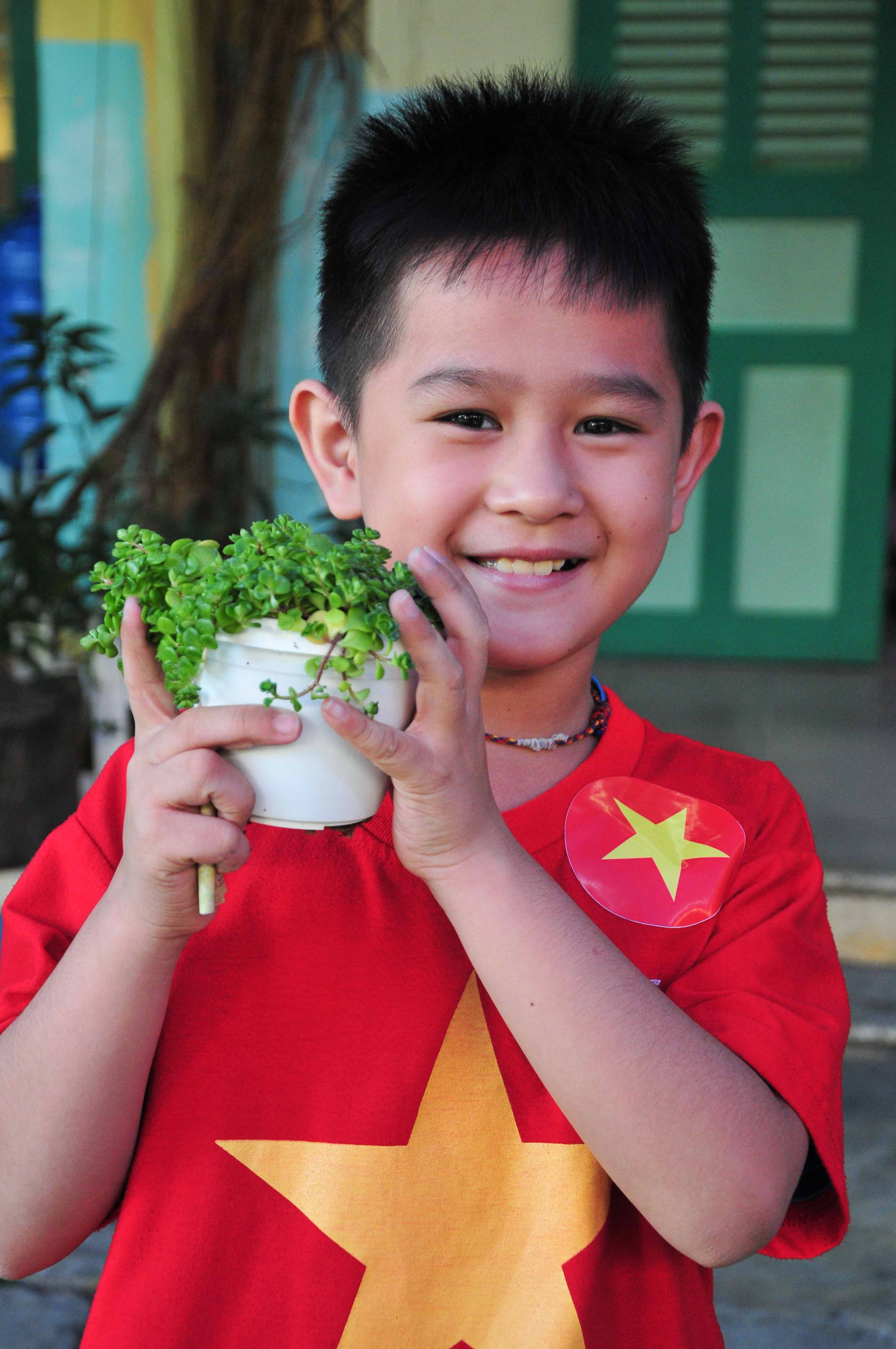 A pupil is happy with his ornamental plant