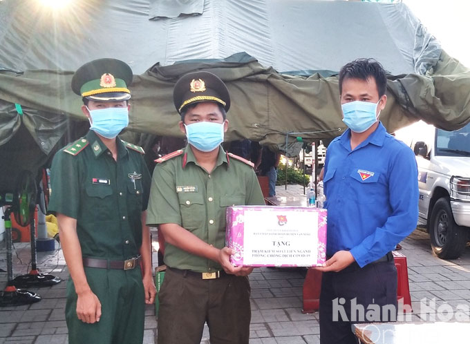 Standing member of Van Ninh District Youth Union offering gifs to forces on duty in Van Tho Commune