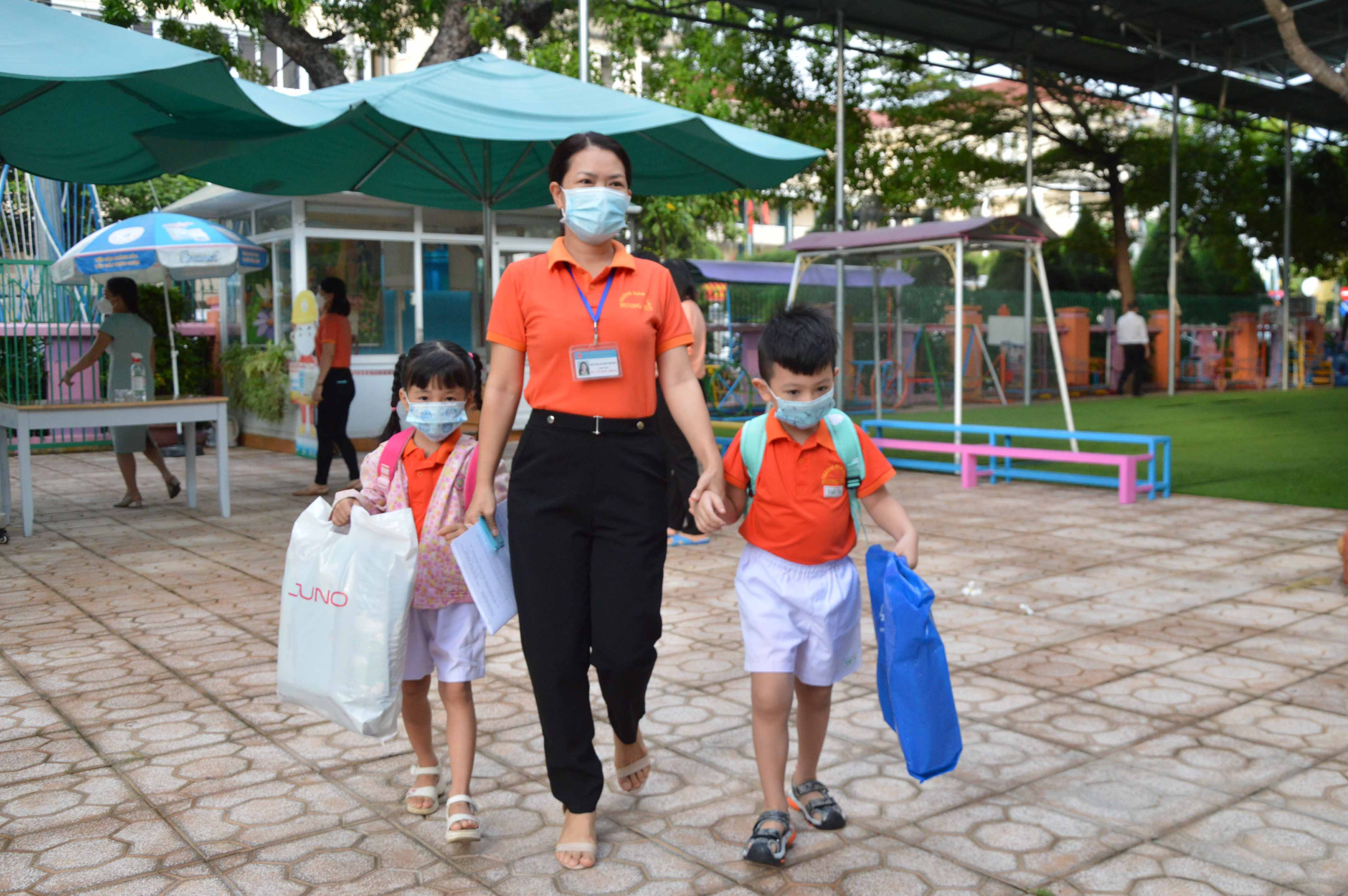 Preschool teacher taking children to classrooms