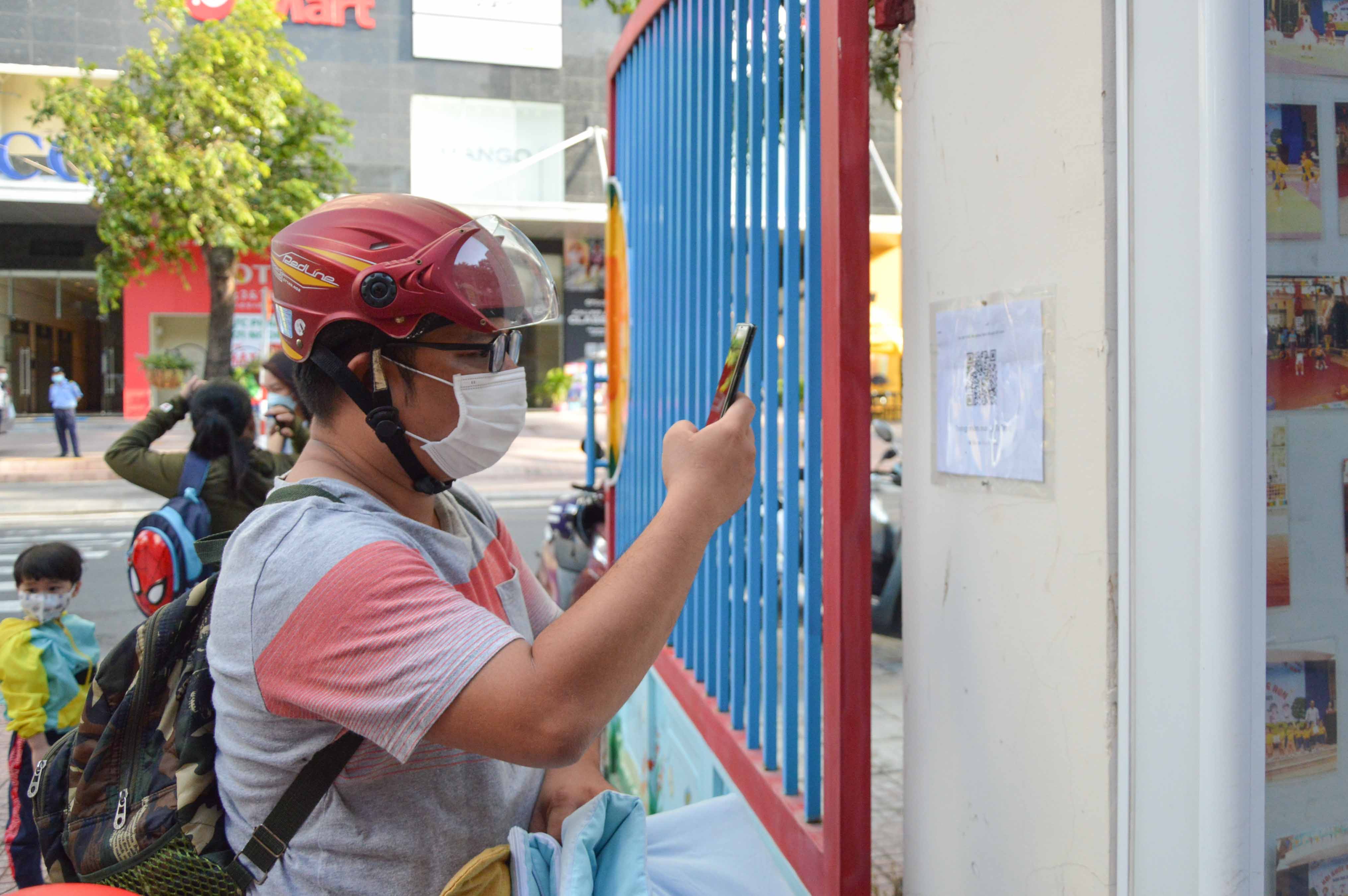 A parent scanning QR code at Ly Tu Trong Preschool, Nha Trang 