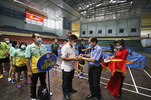 Nguyen Tuan Thanh, deputy director of Khanh Hoa Provincial Department of Culture and Sports offering souvenir flags to teams