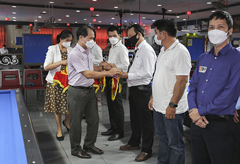 Nguyen Tuan Thanh, deputy director of Khanh Hoa Provincial Department of Culture and Sports, offering souvenir flags to teams 