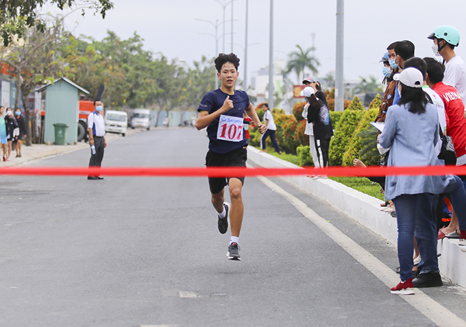 Male teeanager is going to cross the finish line.