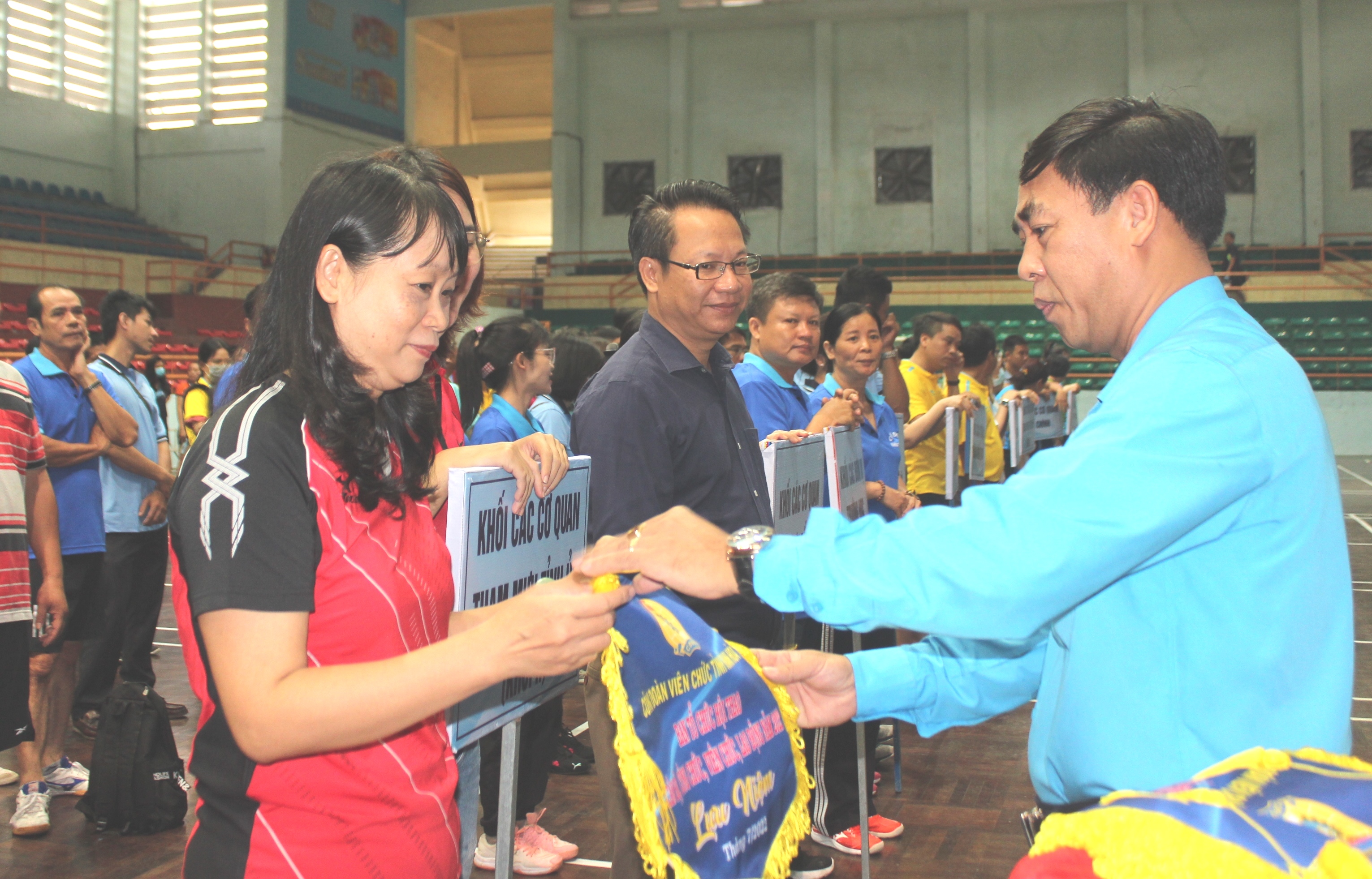 Organization committee giving flowers and souvenir flags to teams