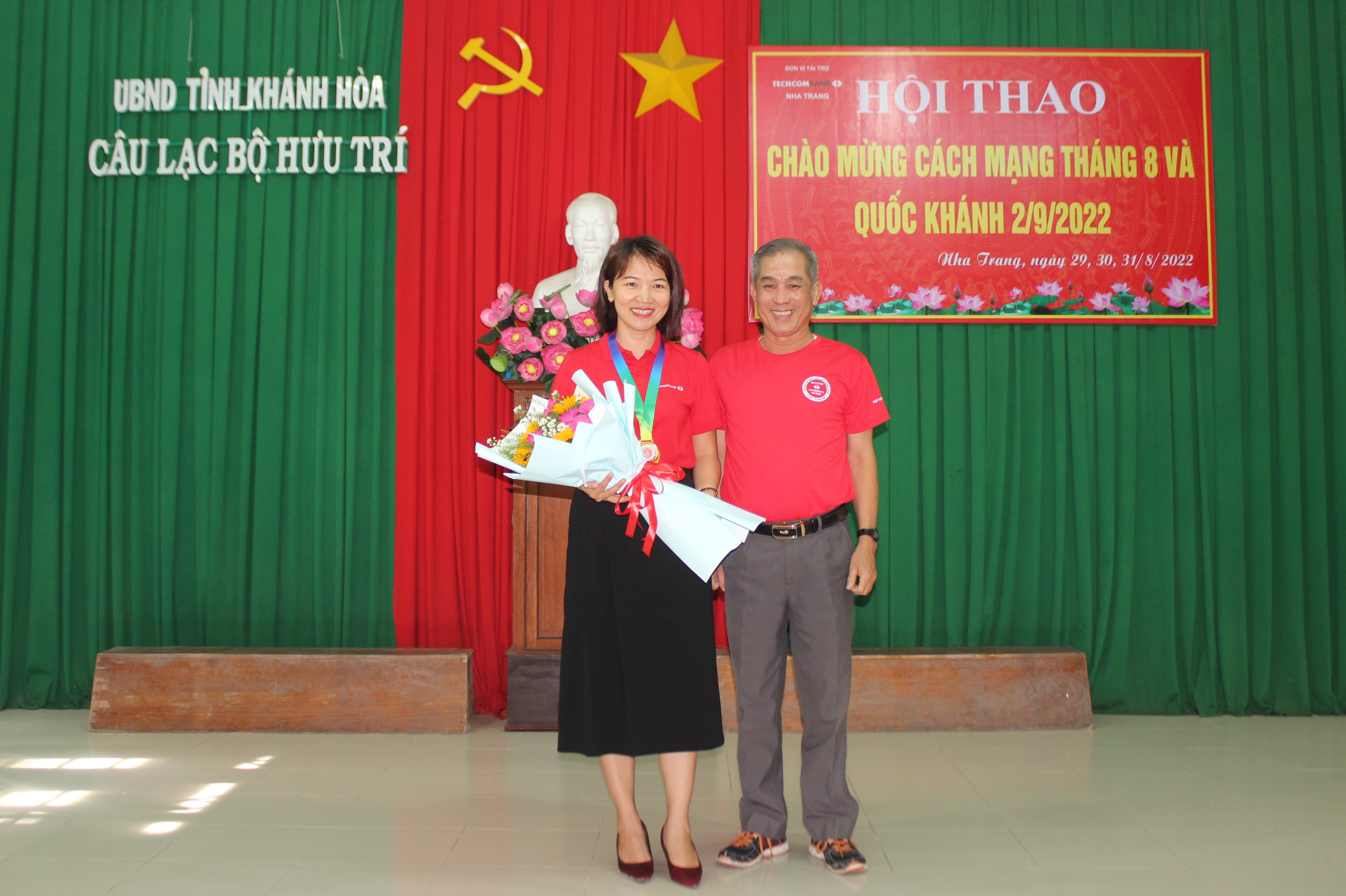 Representative of the club’s Board of Directors presenting flowers to the sponsor unit