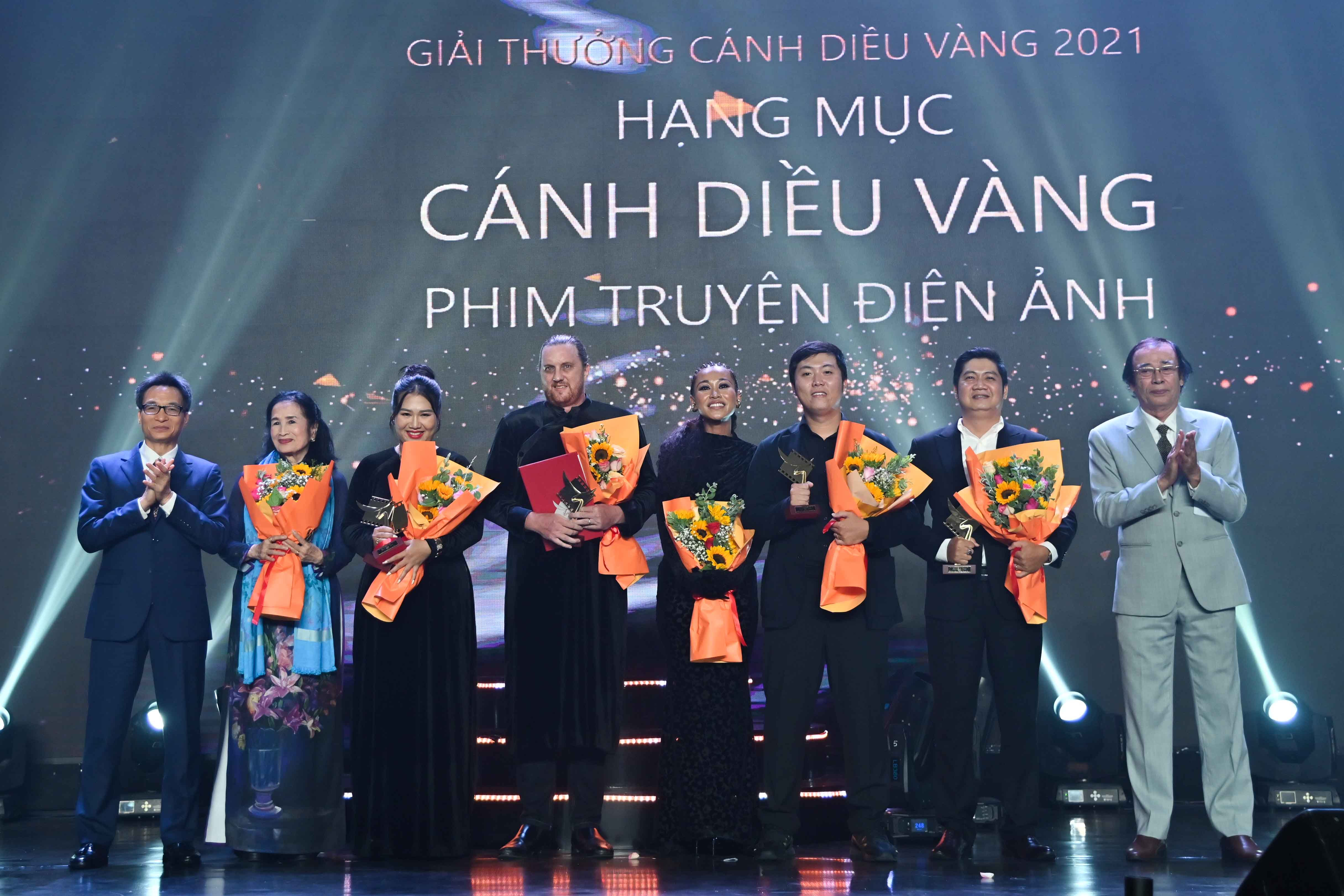 Deputy Prime Minister Vu Duc Dam awarding movie category’s gold prize to the film crew of “Dem toi ruc ro”