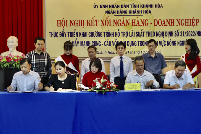 Representative of Agribank Khanh Hoa signing loan agreement with 4 borrowers at the conference connecting banks and enterprises in agriculture