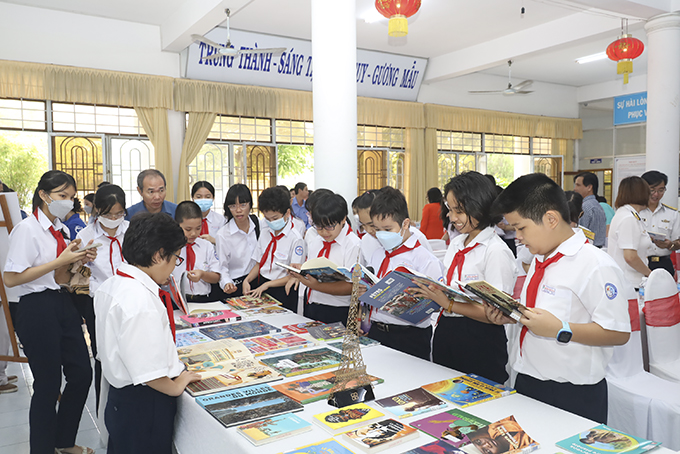 Pupils reading French books at the opening ceremony