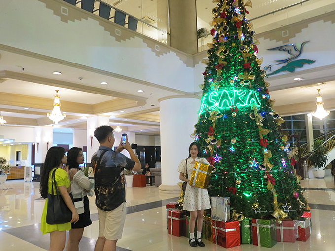 Young people have their photo taken with Christmas decorations at Yasaka Saigon Nha Trang Hotel