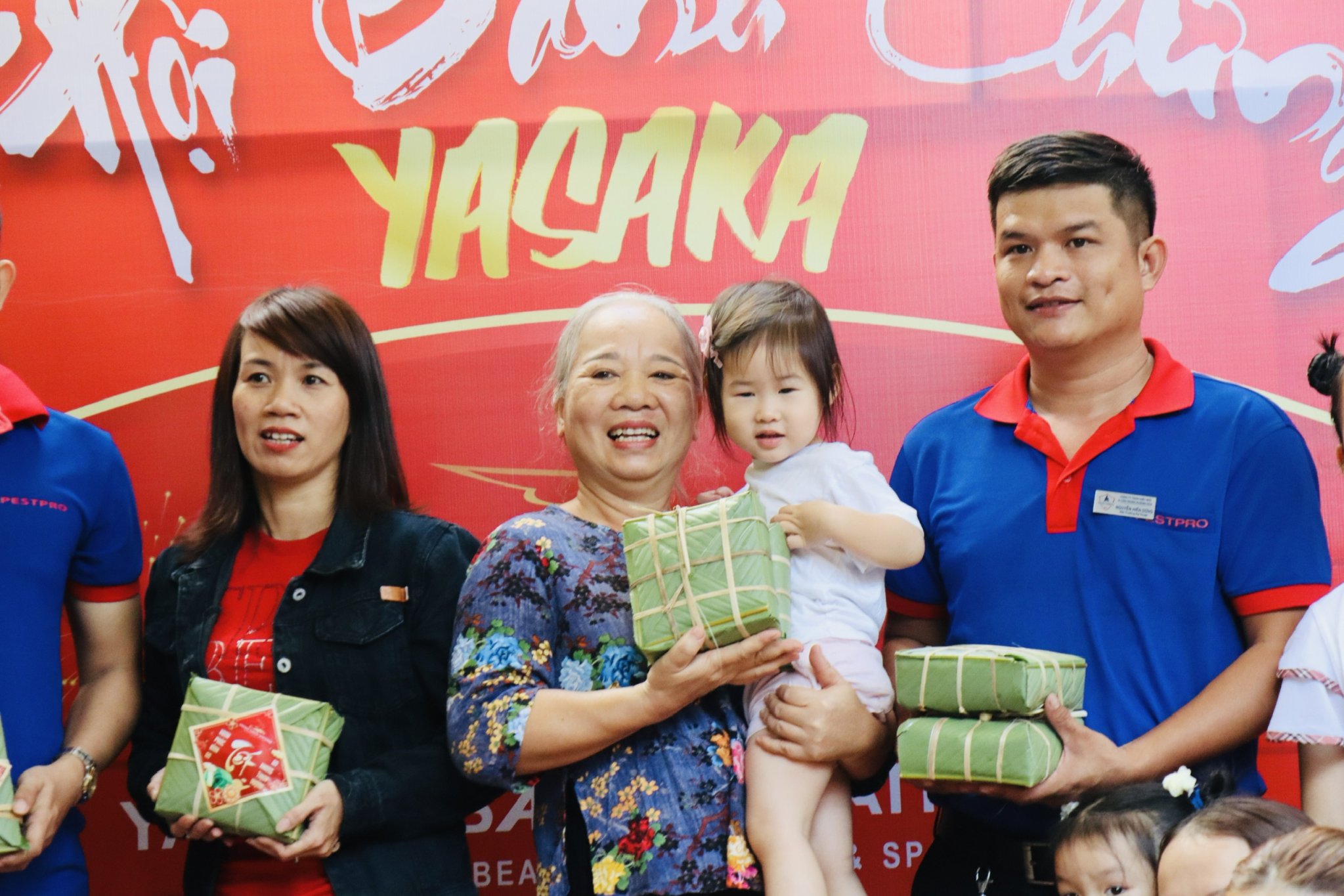 Guests posing with “banh chung” they wrapped