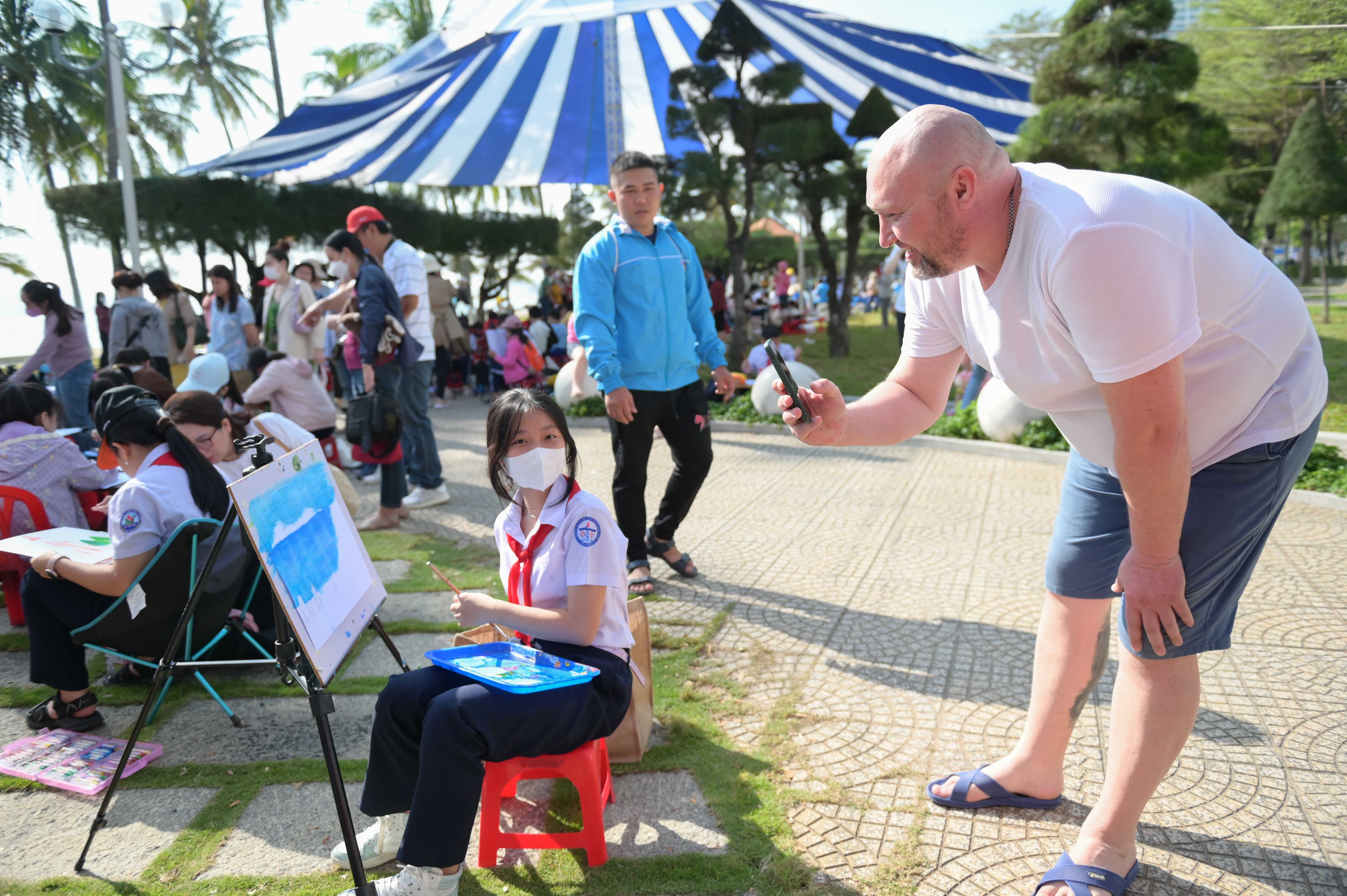 A foreign tourist taking photo of a painting