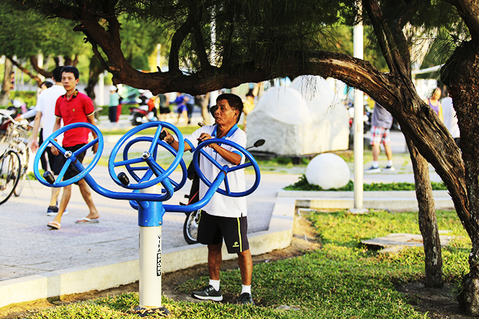 People doing exercise with outdoor fitness equipment